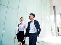 Asian business people in a disussion while walking