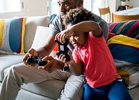 Dad and son playing game at living room together