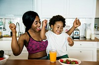 Mother and son eating healthy food in the kitchen