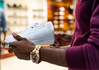 African man holding a white sneakers