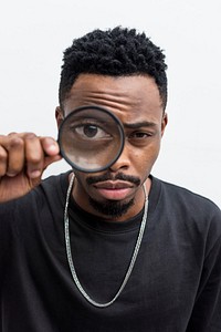 African man playing with a magnifying glass