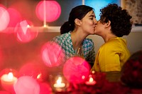 Lesbian couple kissing during dinner
