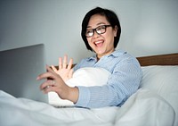A woman working on a laptop in bed