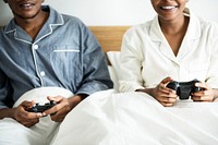 A happy couple playing video game in bed