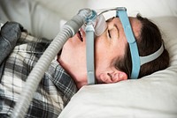 A woman sleeping with anti snoring chin strap