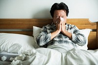 A man suffering from flu sitting in bed
