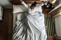 African American woman on bed waking up in the morning