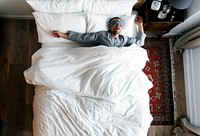 Man on bed sleeping with an eye cover