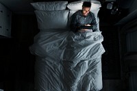 Man on bed using his tablet