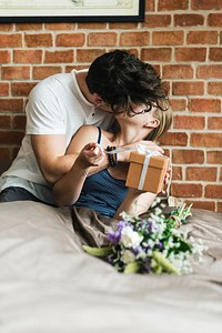 Wife receives a gift box and a bouquet of flower from husband