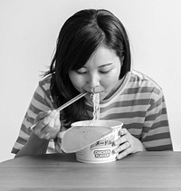 Asian woman eating an instant noodle