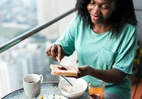 Black woman having breakfast at the balcony