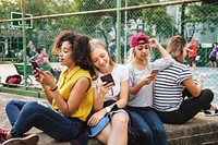 Young adult friends using smartphones together outdoors youth culture concept