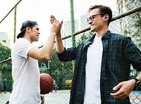 Young adult male friends playing basketball in the park