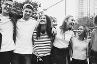 Smiling happy young adult friends arms around shoulder outdoors friendship and connection concept