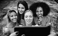 Young adult female friends taking a group selfie