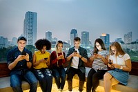 Serious group of young adults using smartphones in the cityscape