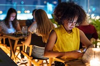Young adult on a dinner date using a smartphone addiction concept