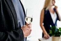 Closeup of man holding white wine glass