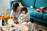 Pregnant woman and daughter playing in a living room together