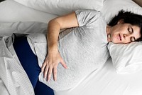 Pregnant woman sleeping on the bed