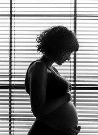Pregnant woman standing by the window