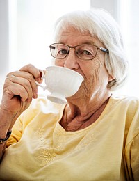 Senior woman sipping tea while looking at the camera