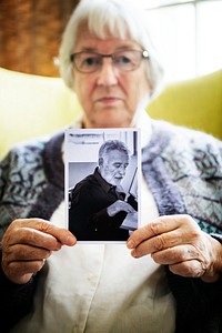 Senior woman holding a photo of a senior man