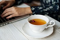 Woman working and a hot cup of floral tea