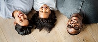 Black family lying on wooden floor design space