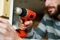 Man using electronic drill install door