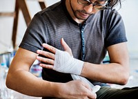 Man bandaging injured hand