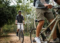 Group of friends ride mountain bike in the forest together