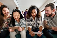 Group of diverse friends playing game on mobile phone