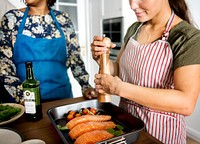 Woman adding spices and herb to raw salmon
