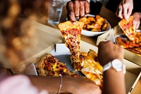 Friends eating pizza together at home