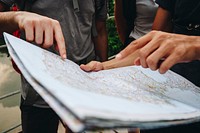 Group of friends looking at a map together travel and teamwork concept