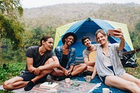 Group of young adult friends in camp site taking a group selfie outdoors recreational leisure, freedom and adventure concept