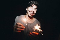 Caucasian man playing with sparklers celebration and festive party concept