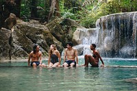 Friends hanging out by a waterfall in the jungle