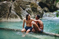 Couple sitting together in a natural pond with clear water