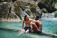 Friends hanging out by a waterfall in the jungle