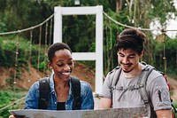 African American woman and a Caucasian man looking at a map together travel and teamwork concept