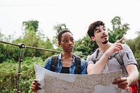 African American woman and a Caucasian man looking at a map together travel and teamwork concept