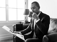 Businessman reading newspaper and having coffee