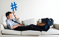 Asian businessman taking break laying on couch