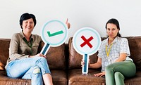 Women sitting on couch holding tick icons