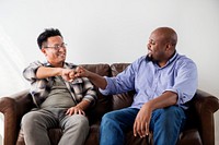 Men fist bumping celebrating on couch