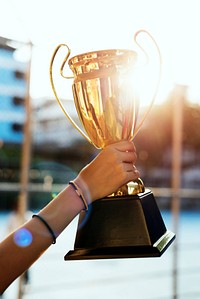 Feminine hand holding a trophy outdoors