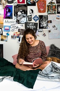 Teenage girl reading a book in a bedroom
